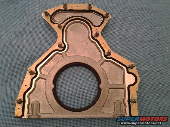 Close-up of a metal engine timing cover gasket with a rubber seal
