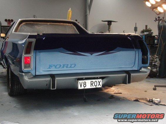 Rear view of a blue Ford Ranchero with custom graphics and a V8 ROX license plate