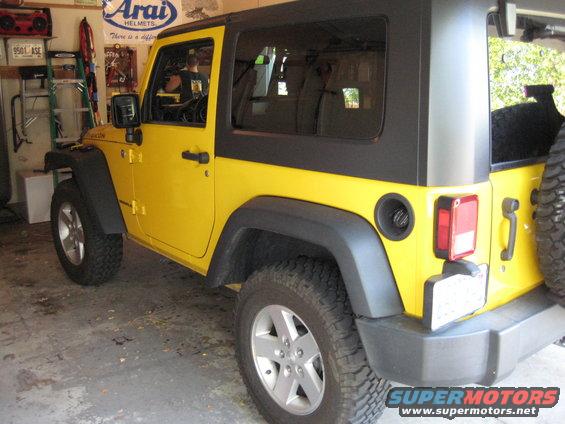 Yellow Jeep Wrangler with black hardtop, 3/4 front view
