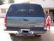 1995 Chevrolet Tahoe - The rear of a dark green Chevrolet Tahoe is shown, with a young girl in red standing to the right.