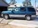 1995 Chevrolet Tahoe - A teal 1995 Chevrolet Tahoe SUV is parked on a concrete driveway next to a garage.