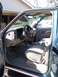1995 Chevrolet Tahoe - The interior of a teal SUV is visible with the driver's side door open, revealing the dashboard and seats.