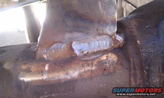 Close-up of a metal component with visible welds and rust