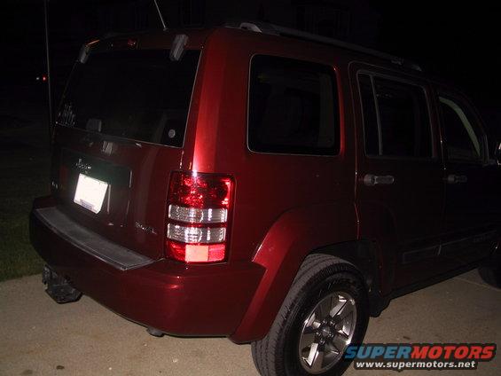 Rear driver's side of a red 2008 Jeep Liberty parked at night