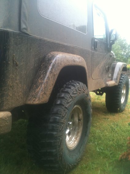 Muddy Jeep Wrangler side view, showing off-road tires and soft top