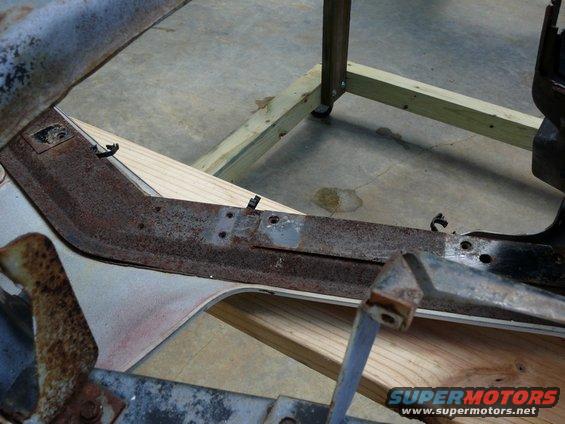 rusted car frame section on wooden supports