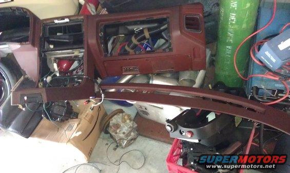 Disassembled brown dashboard interior with exposed wiring and components