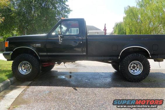 Side view of black 1988 Ford F-150 pickup truck with lifted suspension