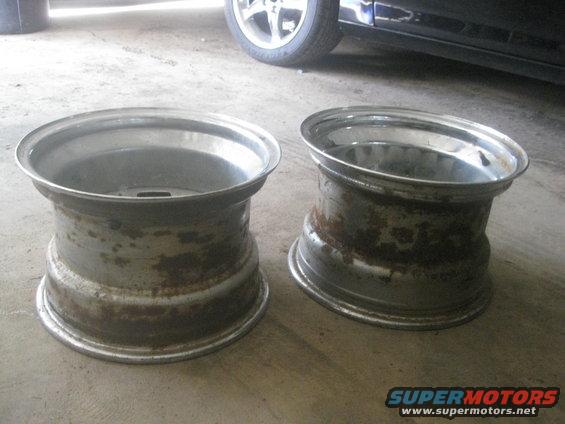Two rusty aluminum wheels on concrete floor