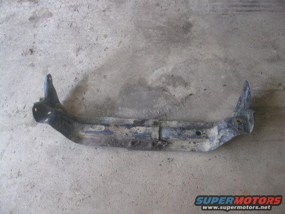 Metal frame part on concrete floor. It has two angled mounting brackets