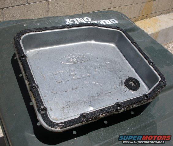 Ford transmission pan with gasket and drain plug hole. Text embossed on pan reads "KELLOGG"
