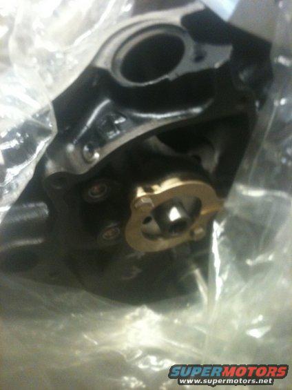 Black engine part with brass fitting, wrapped in plastic