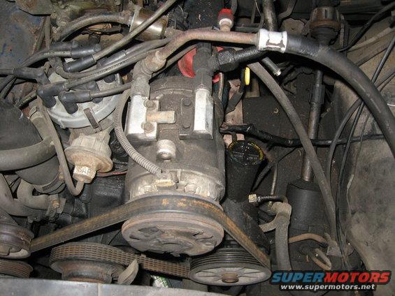 Engine bay with AC compressor, distributor, and belts visible