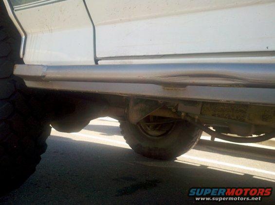 White SUV side view with sliders and large tires