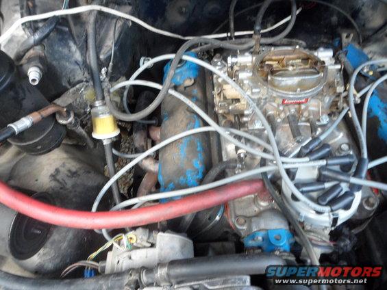 Engine bay with carburetor and fuel filter. Supermotors.net logo visible