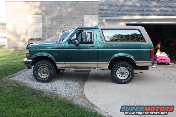 Green 1996 Ford Bronco parked on a driveway, side view