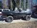 1989 Ford Bronco - This lifted Ford Bronco is parked outside with other vehicles on a sunny day.