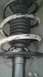 2007 Dodge Caliber - Close-up of a vehicle's front strut assembly, showing the coil spring and dust boot.