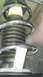 2007 Dodge Caliber - A close-up view of a vehicle's suspension system, a strut and coil spring with a white identification tag.