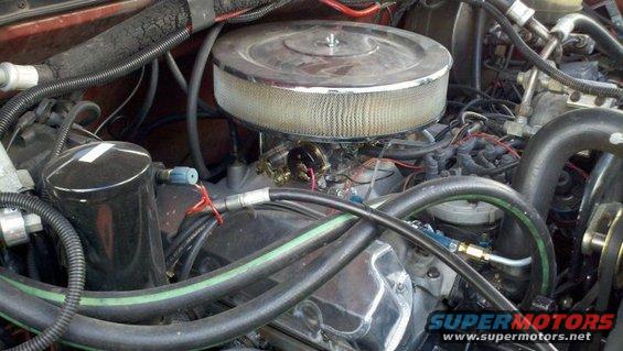Engine bay shot showing a carburetor, air filter, and various hoses and wires