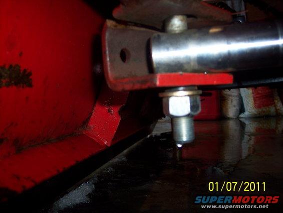 Close-up of red plow attachment with bolt and metal bracket