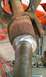 1994 Ford F-250 - A close-up view of a rusty driveshaft universal joint, with various tools laid out on a wooden surface.