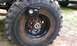 1994 Ford F-250 - A portable air compressor is attached to the wheel of a large vehicle, with another vehicle visible in the background.