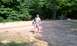 1994 Ford F-250 - A person carries gear through a wooded campsite area with picnic tables and tents visible.