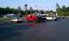 1994 Ford F-250 - A lifted red 1994 Ford F-250 pickup truck with a black hood sits in a parking lot next to other vehicles.