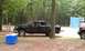1994 Ford F-250 - A black pickup truck is parked at a campsite with laundry hanging on a line in the background.