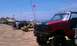 1994 Ford F-250 - A red Ford truck is parked on the sand near the ocean, with other vehicles and people in the background.