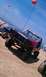 1994 Ford F-250 - A lifted red 1994 Ford F-250 with "DAMAGE INC" on the hood is parked on a sandy beach next to a dune buggy.