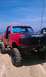 1994 Ford F-250 - Red 1994 Ford F-250 pickup truck with "DAMAGE INC 4X4 CLUB" decal on the hood sits on a sandy beach.