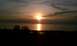 1994 Ford F-250 - Sunset over water with silhouetted trees and land in the foreground. Watermark visible.