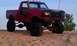 1994 Ford F-250 - This heavily modified pickup truck is parked on a sandy terrain under a clear sky.