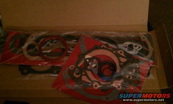 Engine gasket set in packaging, with red and grey gaskets visible