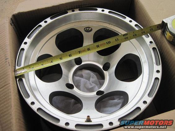 ITP aluminum wheel being measured with a yellow tape measure inside a cardboard box