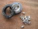 2005 Ford Excursion - A collection of lug nuts and a wheel spacer are laid out on a carpeted surface.