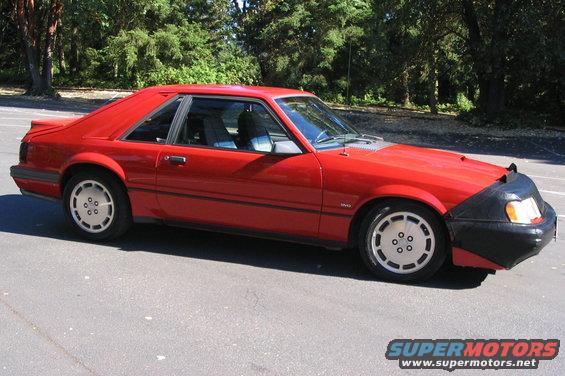 Red 1982 Ford Mustang coupe with a black car bra on the front bumper