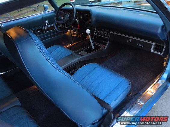 Interior view of a 1972 Chevrolet Camaro with blue seats and dashboard