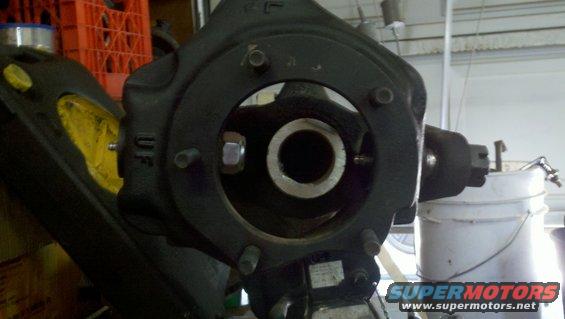 Black metal steering knuckle assembly with bolts and a nut, showing internal components