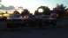 1989 Ford Bronco - Three Ford Bronco SUVs are parked in a lot during twilight.