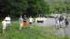 1989 Ford Bronco - A group of people gather near a flatbed trailer in a scenic, wooded location.