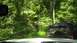 1989 Ford Bronco - A black 1989 Ford Bronco navigates a wooded trail, with another vehicle visible in the distance.