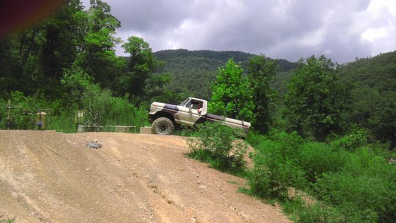 Tan and purple pickup truck on dirt hill