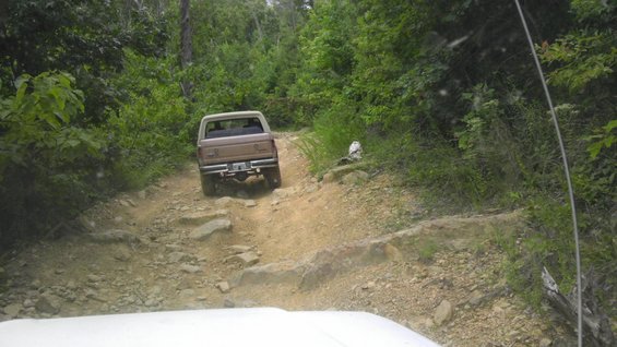 Brown pickup truck on a rocky, off-road trail