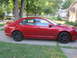 2010 Ford Fusion - Side view of a red 2010 Ford Fusion sedan parked on a residential driveway.