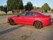 2010 Ford Fusion - A red sedan with black accents is parked in a lot under a clear sky.