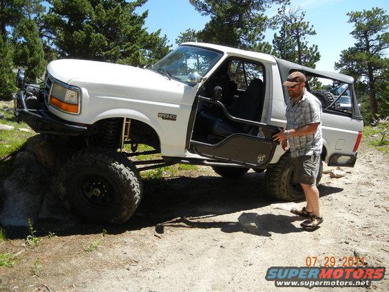 White 1996 Ford Bronco with off-road modifications and open door