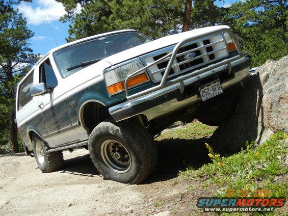 White and green 1996 Ford Bronco on rocky terrain